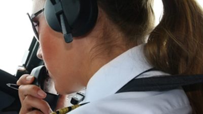 Pilot talking into her radio