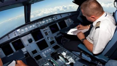 Pilot taking notes in cockpit