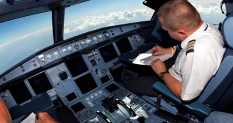 Pilot taking notes in cockpit