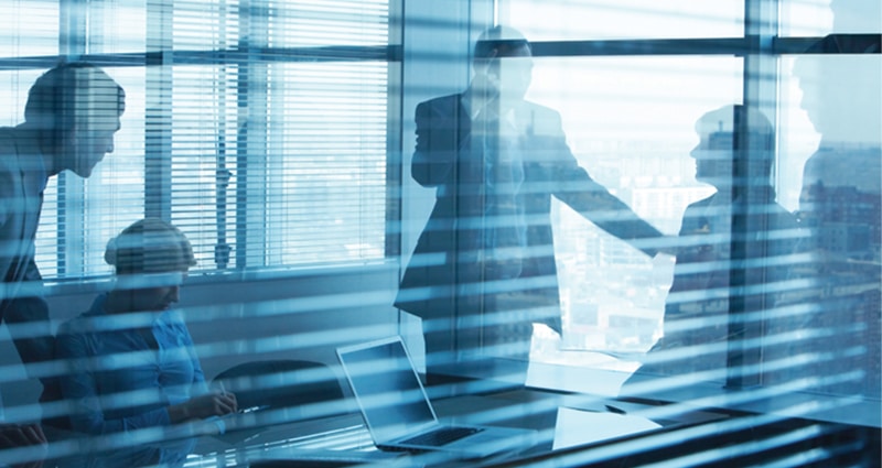 Corporate team meeting in glass conference room