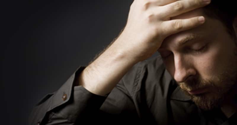 Man with hand on forehead looking distraught