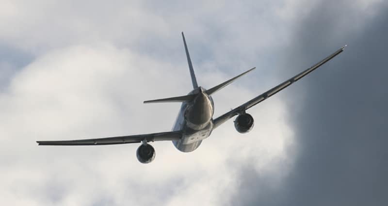 Airplane flying away into clouds