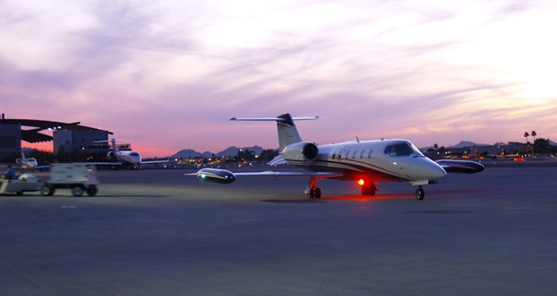 Private jet taxiing at sunset.