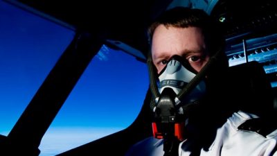 Pilot wearing oxygen mask in cockpit