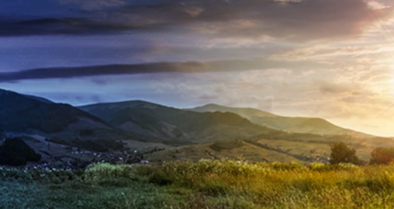 Mountain range behind fields during sunset