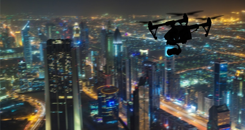 Drone flying at night above large city