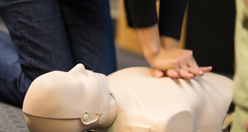 Person administering CPR on dummy