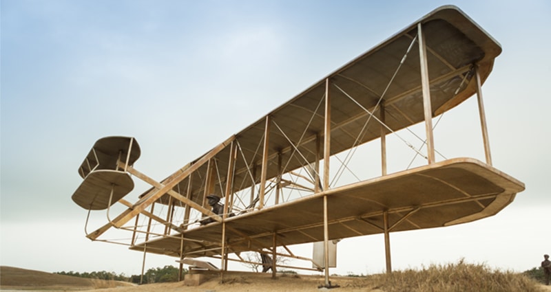 Large wooden biplane on beach