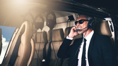 Business man with sunglasses smiling in plane
