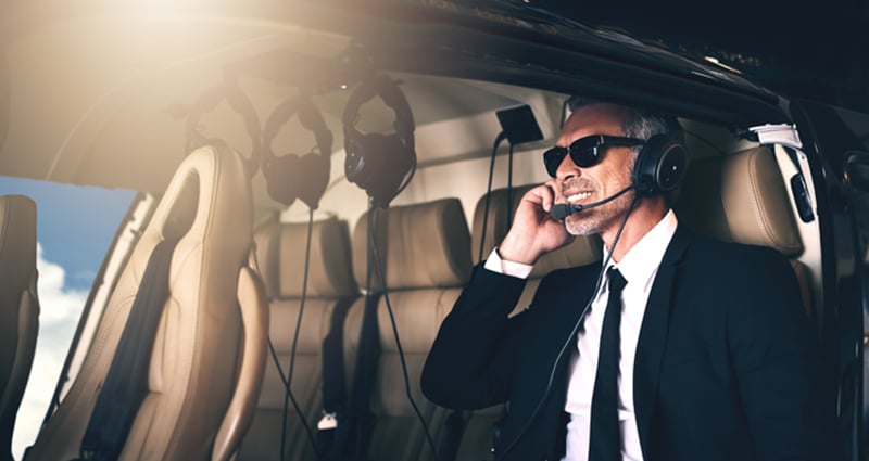 Business man with sunglasses smiling in plane