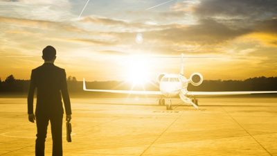 Man with briefcase looking at his private jet