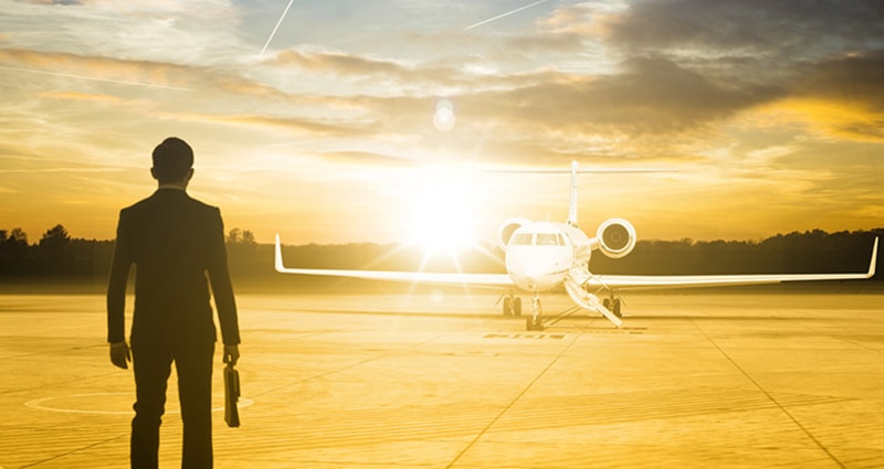 Man with briefcase looking at his private jet