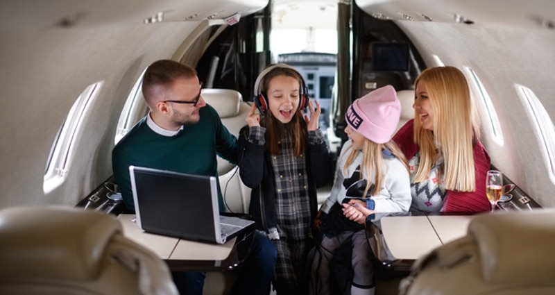 Family of four smiling on plane