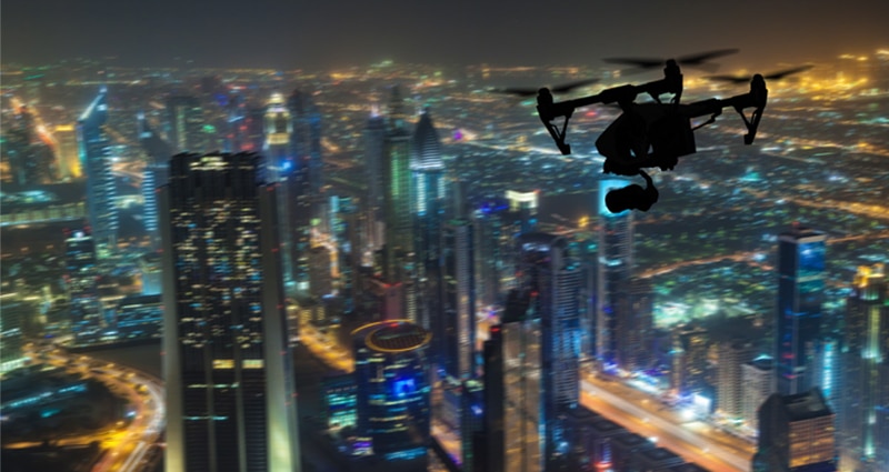 Drone flying at night above large city