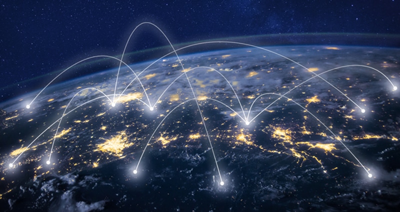 Earth at night with imaginary lines connecting cities