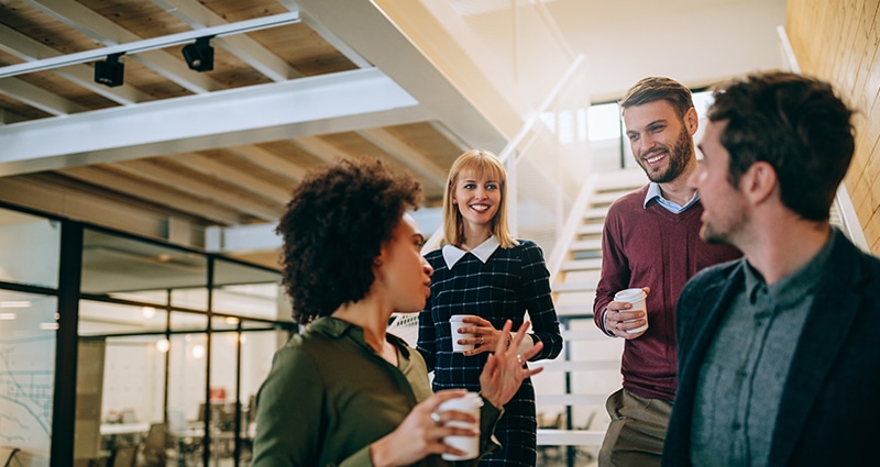 Group of 4 people chatting with coffees