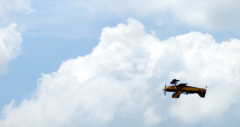 Small plane flying upside down in clouds