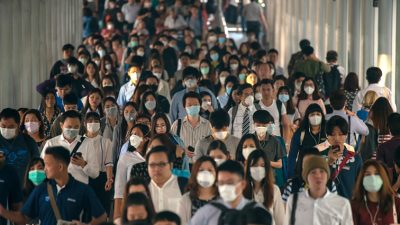 Dozens of masked travelers walking