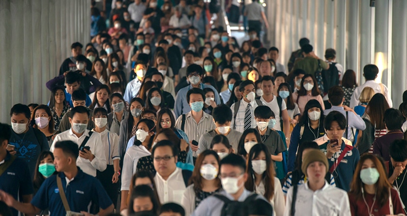 Dozens of masked travelers walking