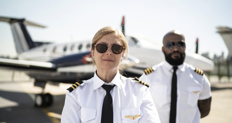 Woman and man pilots standing on runway