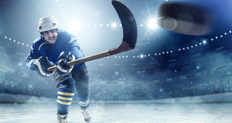 Hockey player on ice shooting puck
