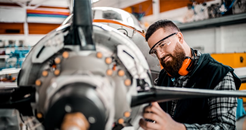 Technician working on airplane propeller