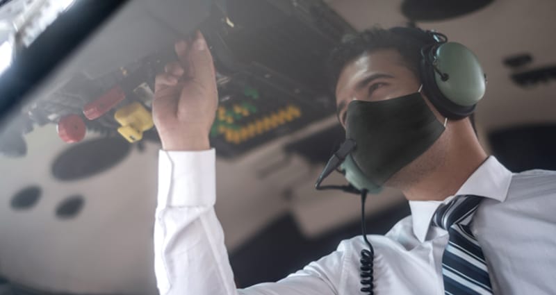 Pilot wearing face mask completing preflight checklist