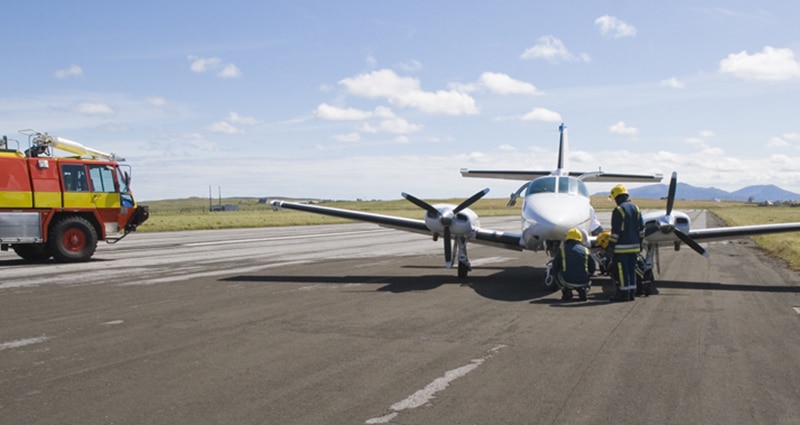 Emergency crew assisting plane on runway