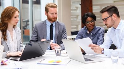 usiness people discussing strategy with a financial analyst