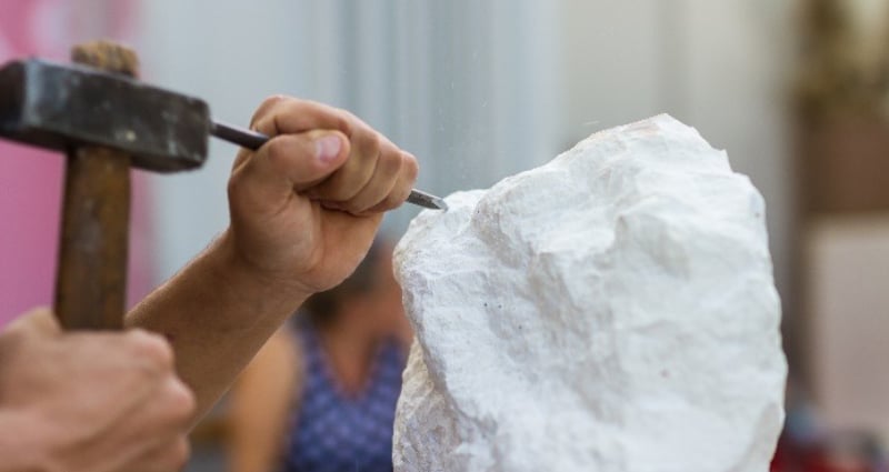 hands chiseling stone