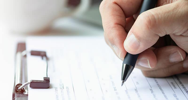 Close-up of hand using writing pen.