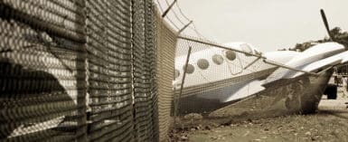 Small plane crashes through fence in emergency landing.