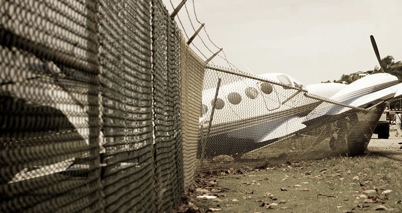 Small plane crashes through fence in emergency landing.