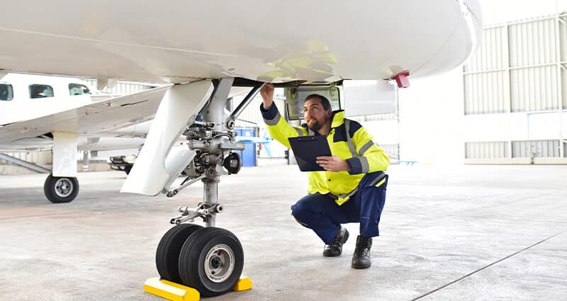 Ground personnel performing safety inspection of an aircraft.