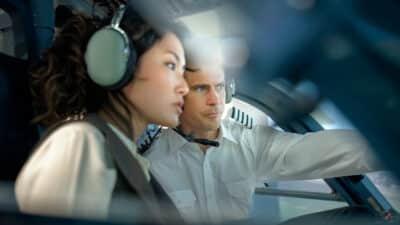 Pilot explaining how a flight simulator works to a student during a training session.