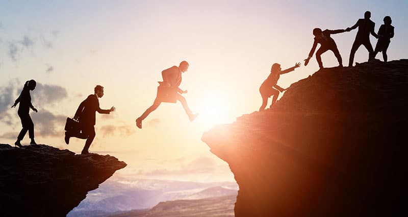 Group of business people climbing a mountain.