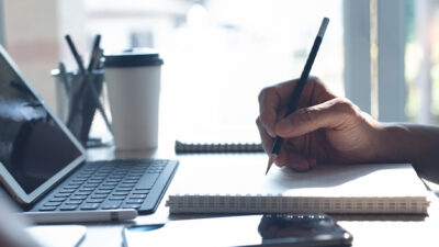 person writing in notebook