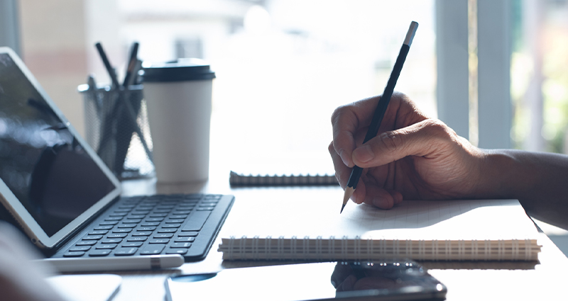 person writing in notebook