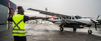 ground crew signaling the pilot with marshalling wands at airport