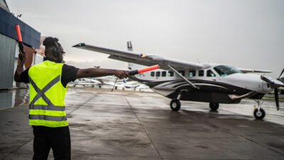 ground crew signaling the pilot with marshalling wands at airport