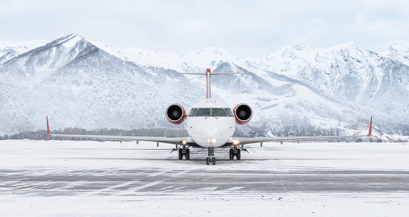 Aircraft on snowy runway in mountains